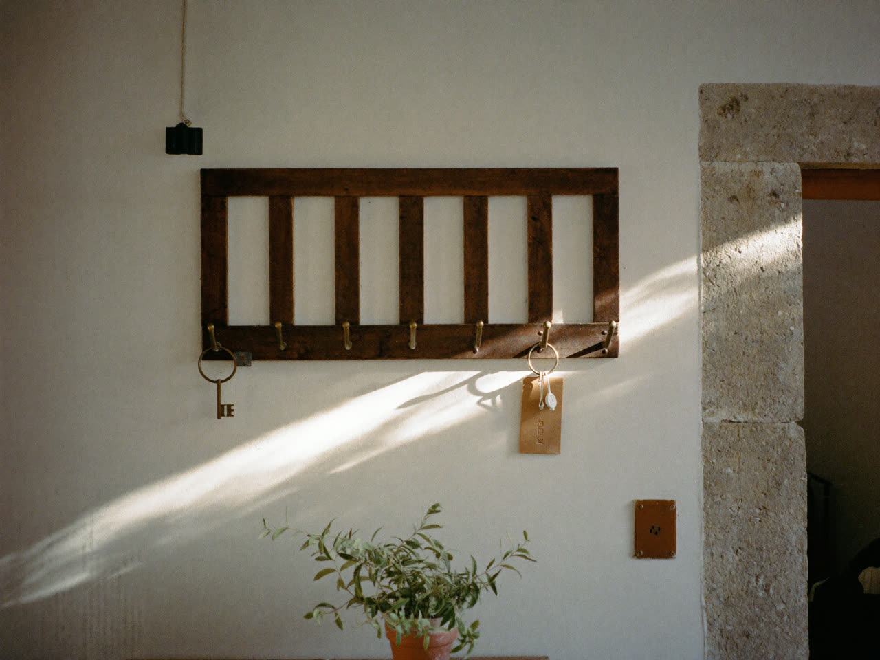 A guesthouse key board with the last keys hanging in morning light